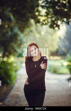 Schöne rothaarige junge Frau ist Wandern im Herbst Park. melancholische Stimmung Stockfoto