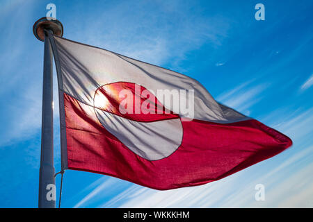 Grönland Flagge - grönländischer Flagge gegen den blauen Himmel. Schuß auf Grönland im Sommer Tag. Die Nationalflagge von Grönland. Stockfoto