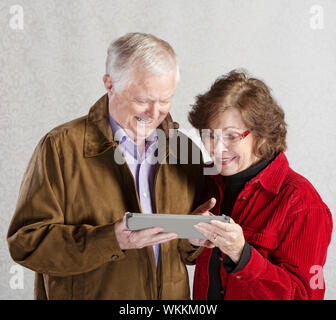 Senior, männliche und weibliche begeistert mit Tablet-computer Stockfoto