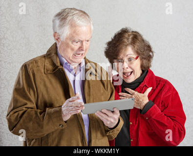 Schockiert Mann und Frau auf der Suche auf Tablet-computer Stockfoto