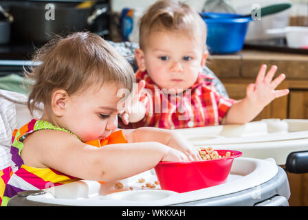 Zwei niedliche Babys essen Frühstück zusammen Stockfoto