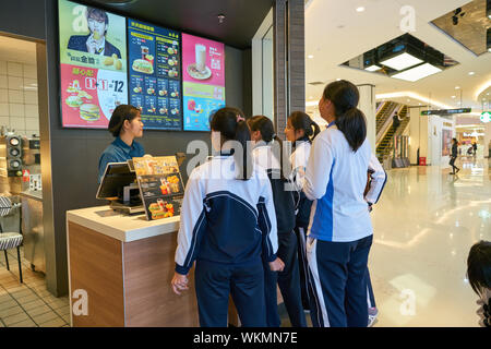 SHENZHEN, China - ca. Januar, 2019: Mitarbeiter, die einen Auftrag von Mädchen bei McDonald's Restaurant. Stockfoto