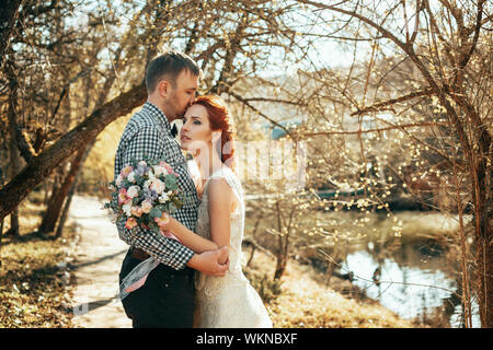 Glückliche Braut und Bräutigam am Tag ihrer Hochzeit. Hochzeit paar in den Wäldern in der Nähe der See. Stockfoto