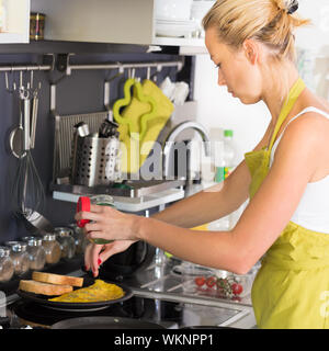 Junge Mutter kochen zu Hause. Stockfoto