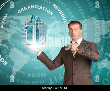 Business mann Wolkenkratzer in der Hand. Die Worte und die Weltkarte im Hintergrund Stockfoto