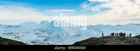 Eisberge in den arktischen Landschaft Natur mit reisen Touristen in Grönland. Die Leute, die auf der Suche an Amazing View Grönlands Eisberge in Ilulissat Icefjord durch den Klimawandel und die globale Erwärmung betroffen. Stockfoto