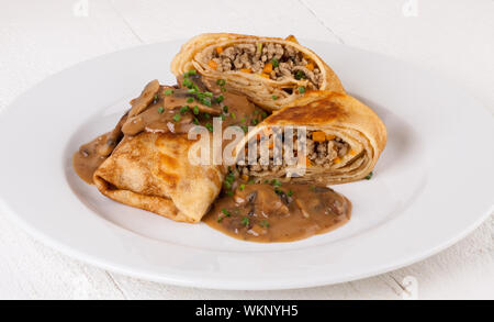 Bohnenkraut Hackfleisch Pfannkuchen oder Tortillas aufgeschnitten, der Boden oder Hackfleisch / Faschiertes und Gemüse füllen in einer reichen leckere Soße zu zeigen Stockfoto