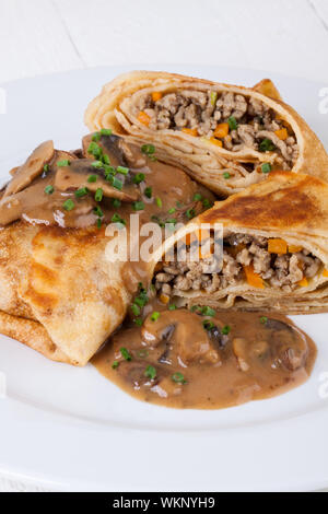 Bohnenkraut Hackfleisch Pfannkuchen oder Tortillas aufgeschnitten, der Boden oder Hackfleisch / Faschiertes und Gemüse füllen in einer reichen leckere Soße zu zeigen Stockfoto