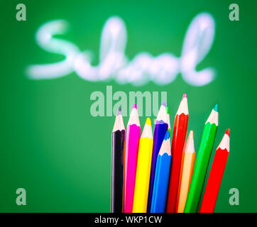 Bunte Bleistifte auf grüne Tafel Hintergrund, soft-Fokus der Handschrift Wort, Lehre der Kunst zurück zum Schulkonzept Stockfoto
