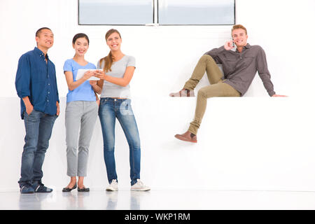 Gruppe von multi-ethnische Freunde mit digitalen Tablet und cell Phon Stockfoto