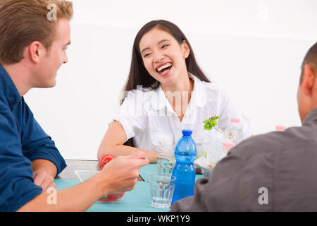Gerne Asiatin Essen mit ihren Freunden Stockfoto
