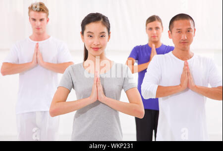 Multi-ethnische Gruppe von fröhlichen Menschen, die Yoga machen Stockfoto