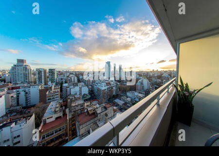 Blick auf die Skyline der Stadt vom Balkon eines Hochhauses Appartement Sonne durch Zwischen schnell bewegen Wolken in Buenos Aires. Stockfoto