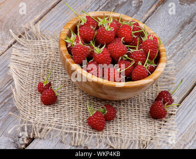 Perfekte Reife Himbeeren mit Stängel in Houten auf rustikalen hölzernen Hintergrund Stockfoto