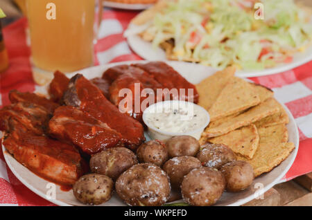 BBQ Ribs mit Nachos, Kartoffeln und Salsa. Stockfoto