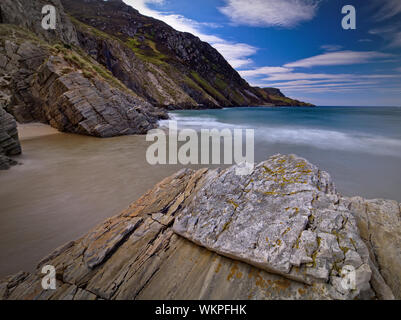 Lange Belichtung Foto der Flut zwischen den Felsen am Maghera Beach, Co Donegal mit riesigen Klippen im Hintergrund Stockfoto
