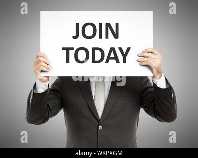 Ein Mann hält ein Papier vor seinem Gesicht mit dem Text melden Sie sich noch heute Stockfoto