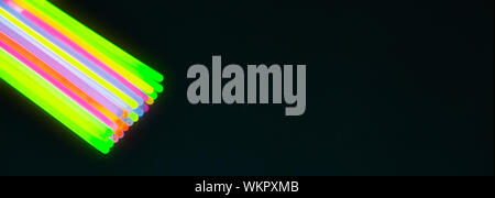 Neue Farben der Leuchtstäbe für Nacht Party, auf schwarzem Hintergrund. Panorama banner Größe Stockfoto