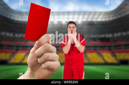 Das zusammengesetzte Bild von Hand bis rote Karte gegen Spieler gegen Stadion voller Deutschland Fußball-Fans Stockfoto