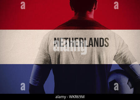 Niederlande fußball Spieler mit Ball gegen nationale niederländische Flagge Stockfoto