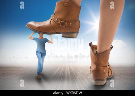 Das zusammengesetzte Bild von Cowboy Stiefel treten auf Mädchen gegen Stadtbild am Horizont Stockfoto