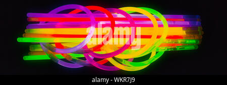 Neue Farben der Leuchtstäbe für Nacht Party, auf schwarzem Hintergrund. Panorama banner Größe Stockfoto