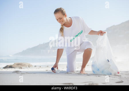 Blond Aktivist Abholung Müll am Strand an einem sonnigen Tag Stockfoto