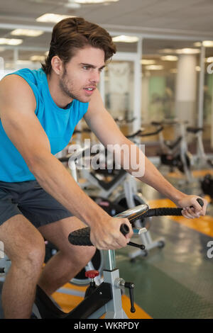 Fokussierte passen Mann auf der Spin Bike an der Turnhalle Stockfoto