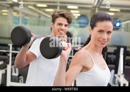 Fit Paar heben Barbells zusammen an der Turnhalle Stockfoto