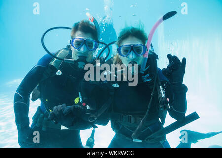 Freunde auf scuba Training unter Wasser im Pool zu Kamera schaut auf Ihren Urlaub Stockfoto