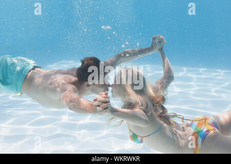 Nettes paar Küssen unter Wasser in den Pool für Ihren Urlaub Stockfoto