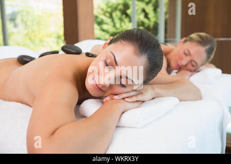 Ruhig Freunde liegen auf Massage mit heißen Steinen auf dem Rücken im Health Spa Stockfoto