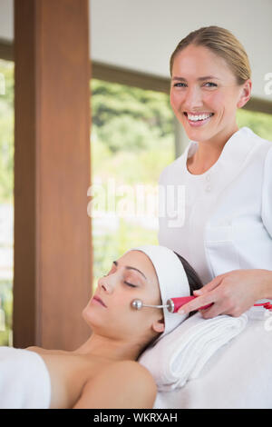 Brunette getting Micro Dermabrasion mit Therapeut lächelt Kamera im Health Spa Stockfoto