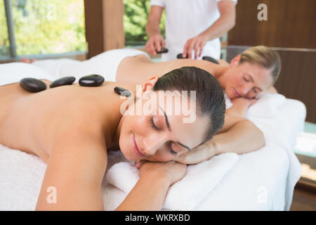 Ruhig Freunde liegen auf Massage mit heißen Steinen auf dem Rücken im Health Spa Stockfoto