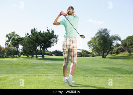 Weibliche Golfspieler eine Aufnahme, an einem sonnigen Tag auf dem Golfplatz Stockfoto