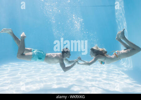 Nettes Paar Hände halten unter Wasser in den Pool für Ihren Urlaub Stockfoto