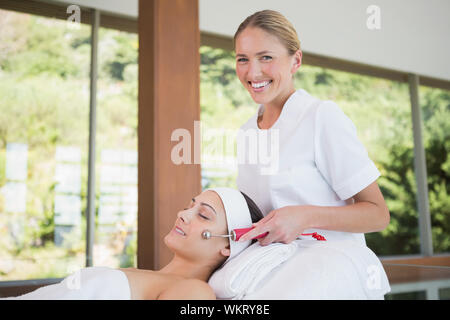 Brunette getting Micro Dermabrasion mit Therapeut lächelt Kamera im Health Spa Stockfoto