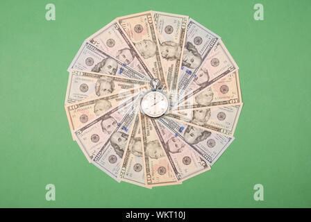 Stoppuhr auf dem Mandala Kaleidoskop von Geld. Abstrakte Geld Hintergrund raster Muster wiederholen Mandala Kreis. Stockfoto