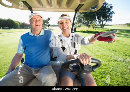 Viel Spaß paar im Golf buggy sitzen an einem sonnigen Tag auf dem Golfplatz Stockfoto