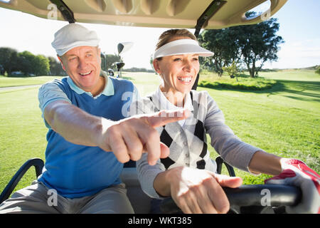 Viel Spaß paar im Golf buggy sitzen an einem sonnigen Tag auf dem Golfplatz Stockfoto
