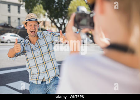 Happy hip Mann für seine Freundin an einem sonnigen Tag in der Stadt posing Stockfoto