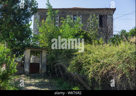 Abgebrochene Stein altes Haus mit Büschen bewachsene Stockfoto