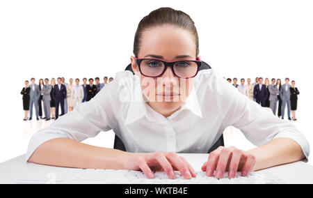 Das zusammengesetzte Bild der Unternehmerin die Eingabe über die Tastatur gegen die Gruppe der Arbeitnehmer Stockfoto