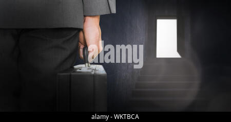 Geschäftsmann holding Aktenkoffer gegen graue Treppe zum Tür öffnen Stockfoto