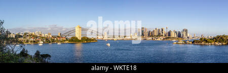 Sydney Sehenswürdigkeiten Panorama Blick auf die Stadt durch den Sydney Harbour entlang Harbour Bridge Bogen in Richtung Stadtbild Wolkenkratzer bei Sonnenaufgang Stockfoto