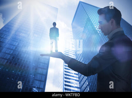 Das zusammengesetzte Bild im Geschäftsmann holding Architekten gegen Low Angle View der Wolkenkratzer Stockfoto