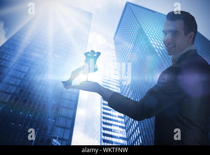Das zusammengesetzte Bild im Geschäftsmann Holding business Mann in Drehstuhl gegen Low Angle View der Wolkenkratzer Stockfoto