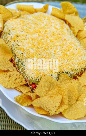 Tortilla Chips mit 7 Schicht bean Dip für Outdoor Picknick party Vorspeise Stockfoto