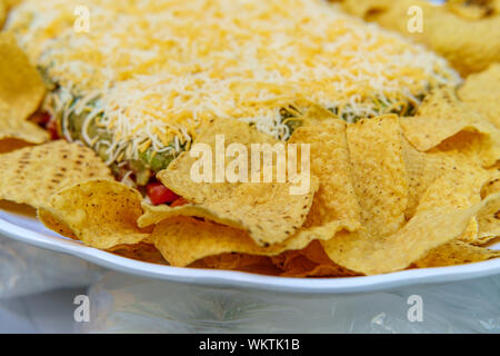Tortilla Chips mit 7 Schicht bean Dip für Outdoor Picknick party Vorspeise Stockfoto