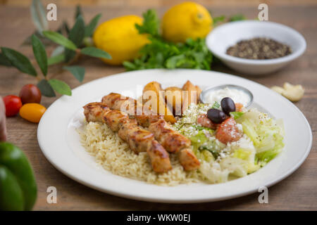 Griechische chicken kabobs auf Reis mit Kartoffeln. auf weißem Teller serviert Stockfoto